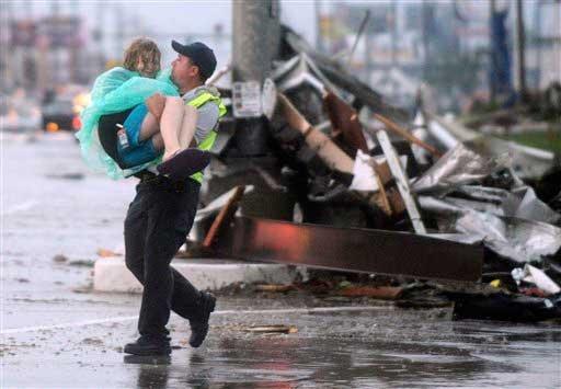 Emergency worker carries victim from danger.